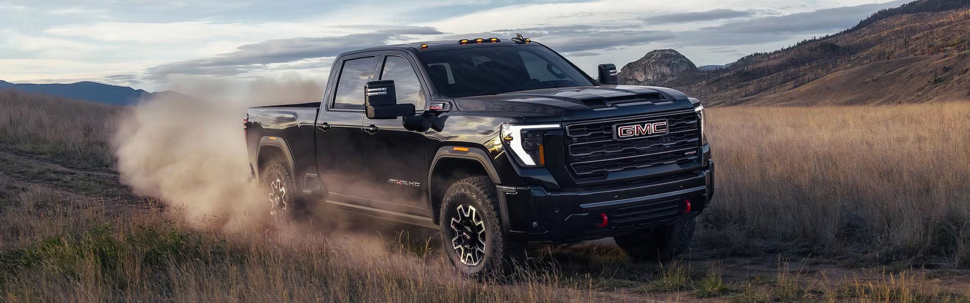 Black GMC truck driving through rugged terrain near HEREFORD, TX at Stevens 5-Star Car & Truck Center GMC.